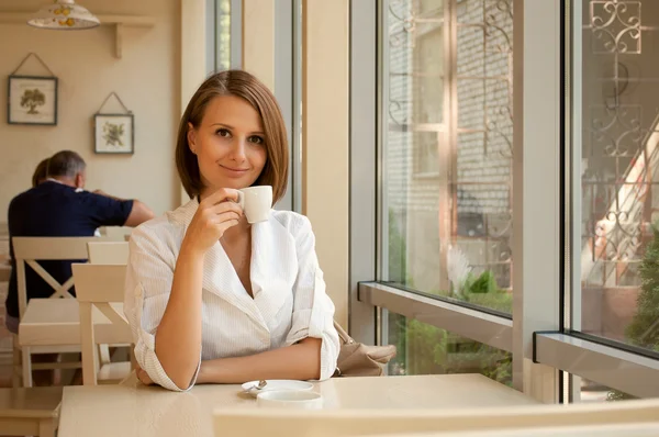 Das Mädchen sitzt im Café — Stockfoto