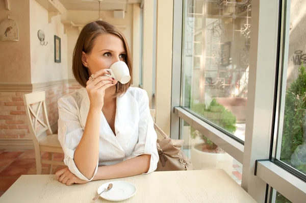 A lány kávézóban iszik kávét — Stock Fotó