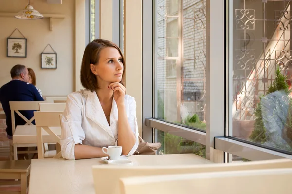 A lány ül, az ablak közelében kávézó — Stock Fotó