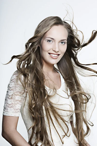 Красивая улыбающаяся девушка с длинными прекрасными волосами — стоковое фото
