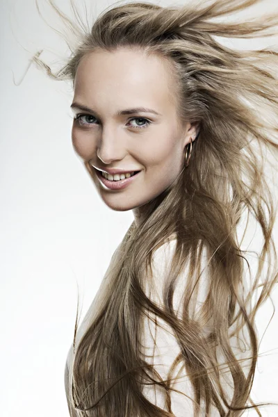 Красивая улыбающаяся девушка с длинными прекрасными волосами — стоковое фото