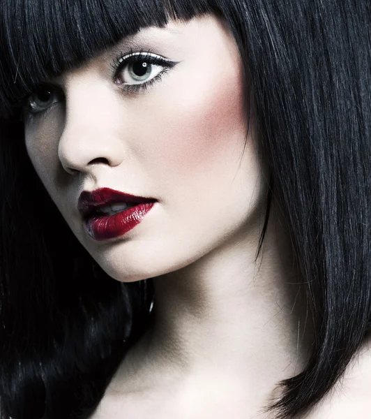 Bella ragazza con pelle perfetta, rossetto rosso e capelli neri sulla schiena bianca — Foto Stock