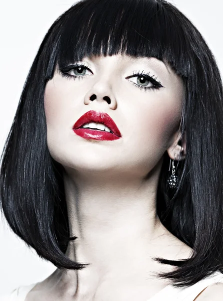 Schönes Mädchen mit perfekter Haut, rotem Lippenstift und schwarzen Haaren auf weißem Rücken — Stockfoto