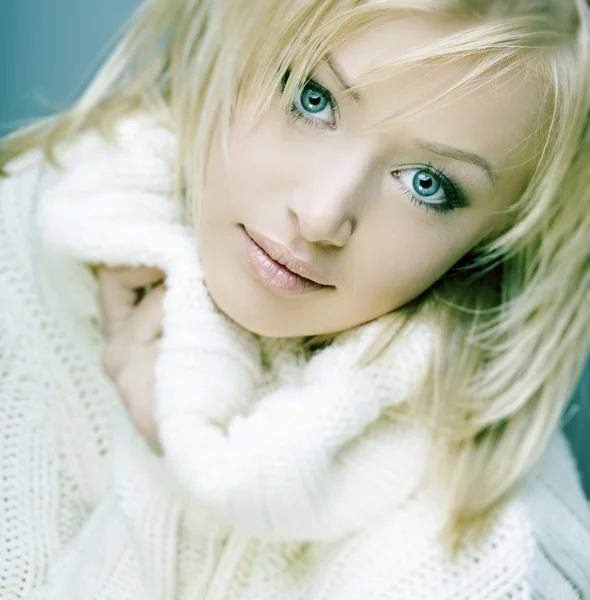 Krásná dívka s dokonalou pleť, blonďaté vlasy a modré oči v bílém svetru — Stock fotografie