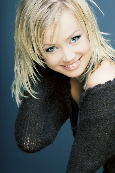 Krásná usměvavá dívka s dokonalou pleť, blonďaté vlasy a modré oči v černém — Stock fotografie