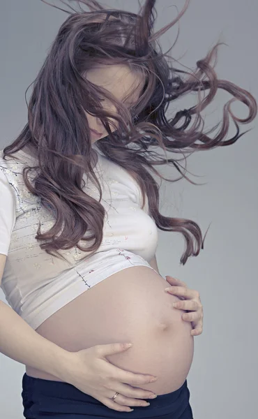 Szép terhes nő hosszú hajjal mosolyog — Stock Fotó