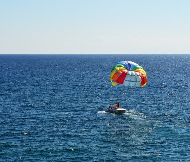 bir deniz üzerinde renkli paraşüt