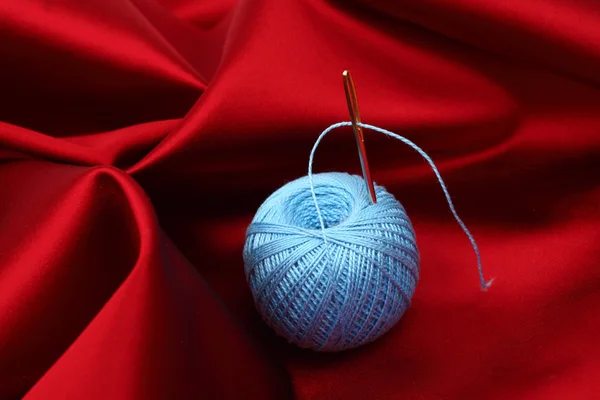 Thread on red silk — Stock Photo, Image