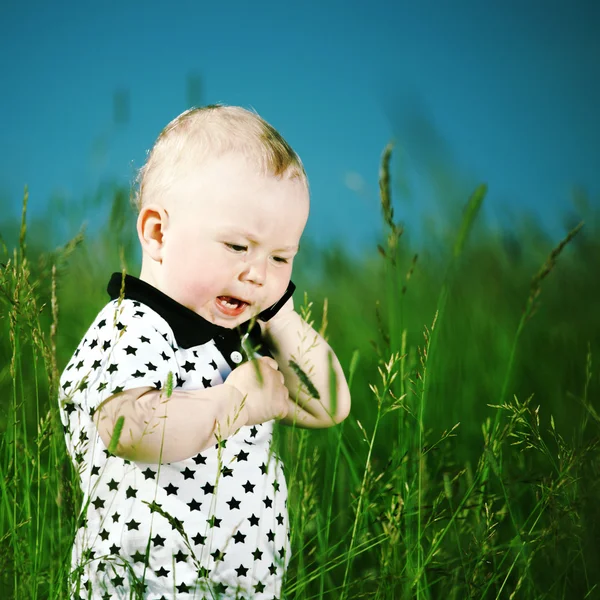 Chłopiec w trawie rozmowy przez telefon — Zdjęcie stockowe