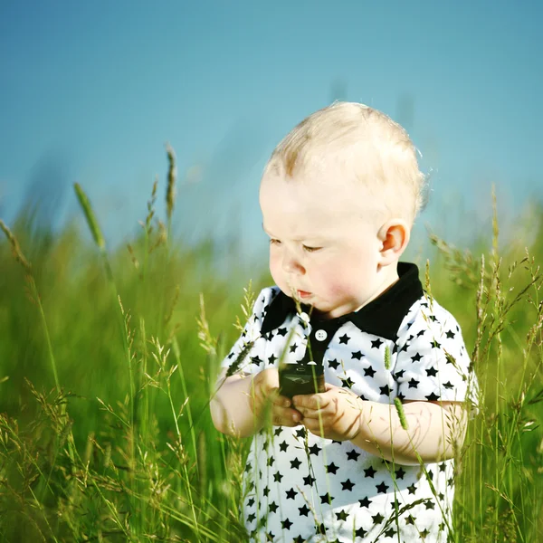 Хлопчик в траві дзвонить по телефону — стокове фото