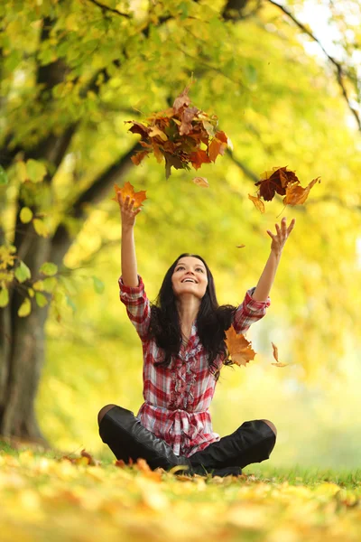 女人滴树叶在秋天公园 — 图库照片