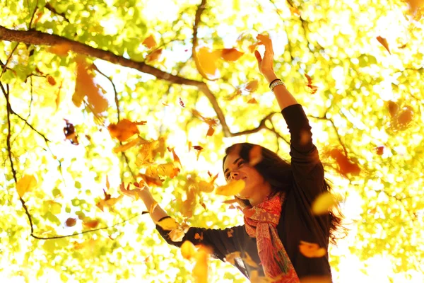 Donna foglie goccia nel parco autunnale — Foto Stock