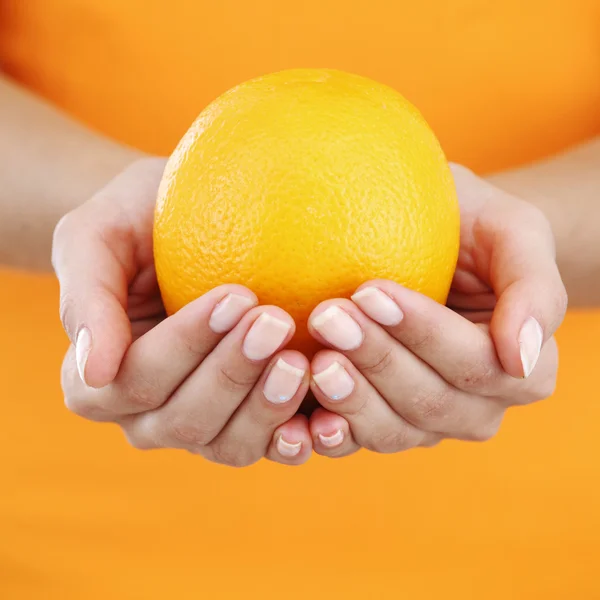 Orange dans les mains de la femme — Photo