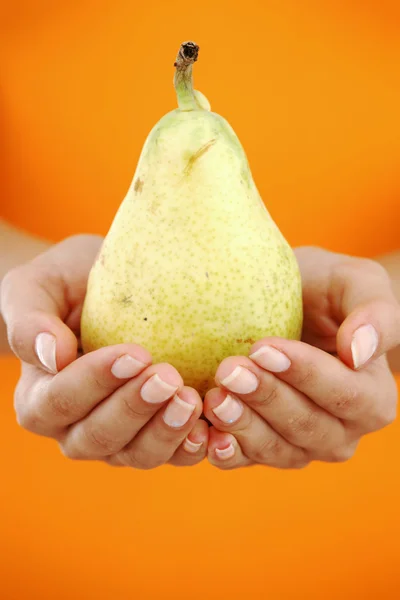 Pear in woman hands — Stock Photo, Image