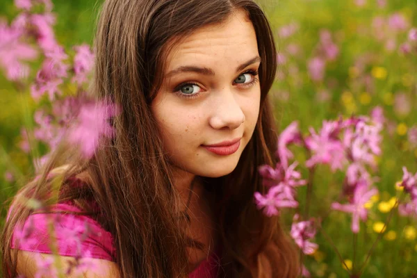 Nainen vaaleanpunaisella kukkapellolla — kuvapankkivalokuva