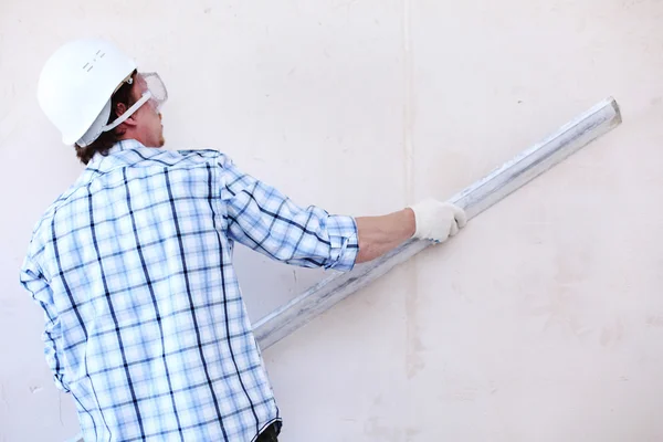 Arbetstagaren justerar väggen — Stockfoto