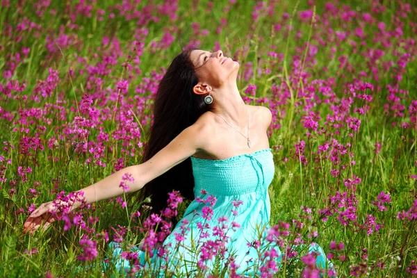 Žena na poli růžový květ — Stock fotografie