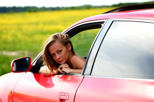 Femme en voiture rouge Image En Vente