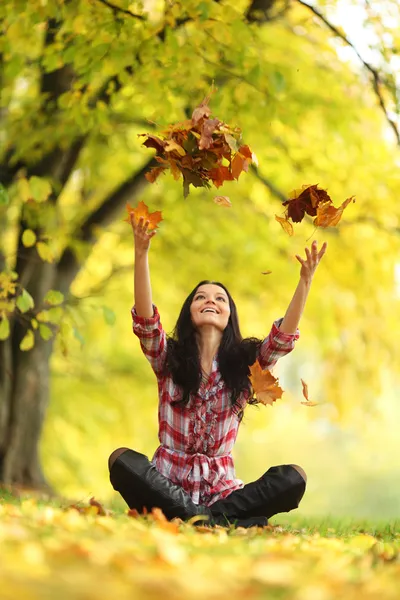 Mujer caída hojas en otoño parque Fotos De Stock Sin Royalties Gratis