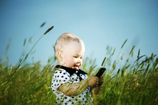 소년 잔디에 있는 전화로 전화 — 스톡 사진