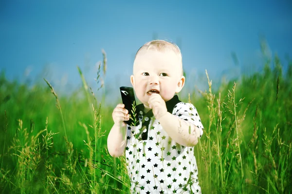 Jongen in gras gesprek via de telefoon — Stockfoto