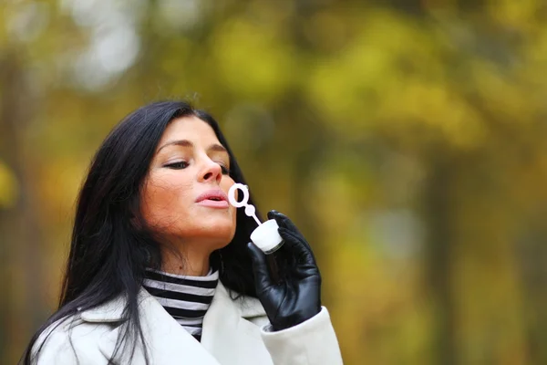 Autumn woman blow bubbles — Stock Photo, Image
