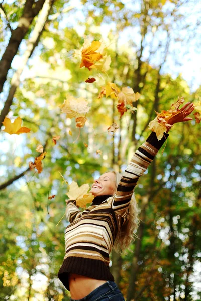 Femme goutte feuilles dans le parc d'automne — Photo