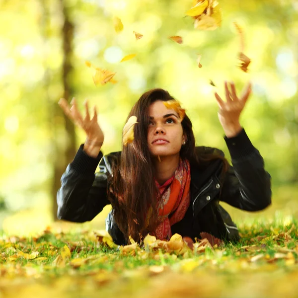 Frau wirft Blätter im Herbstpark ab — Stockfoto