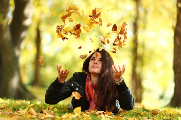 Woman drop leaves in autumn park — Stock Photo, Image