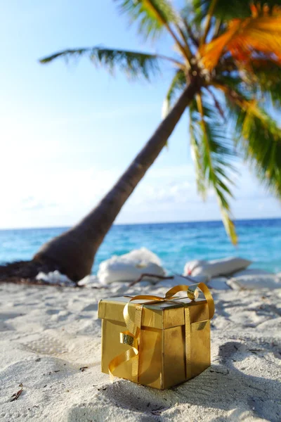 Golden cadeau op oceaan strand — Stockfoto