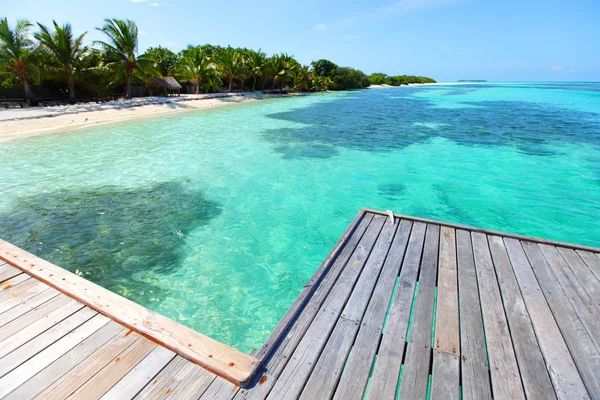 Resort maldivian domy v modrém moři — Stock fotografie