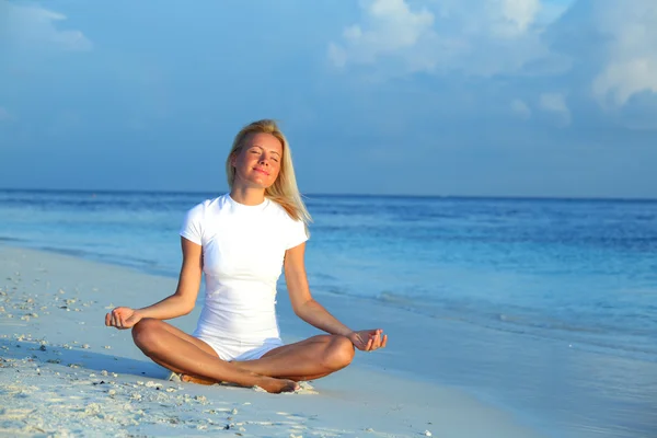 Donna yoga sulla costa del mare — Foto Stock