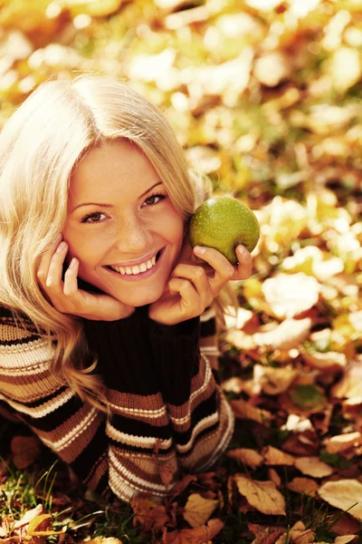 Woman eat apple in autumn park — Stock Photo, Image