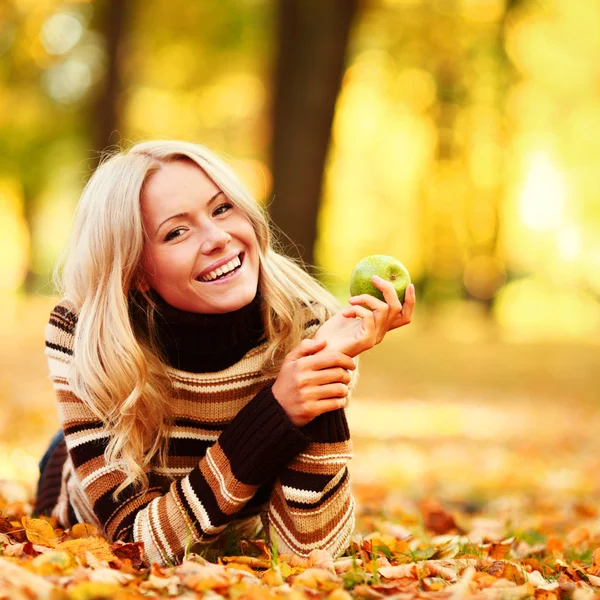 Frau isst Apfel im Herbstpark — Stockfoto