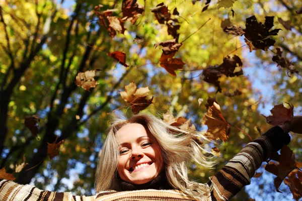 Kobieta kropla liści w parku jesień — Zdjęcie stockowe