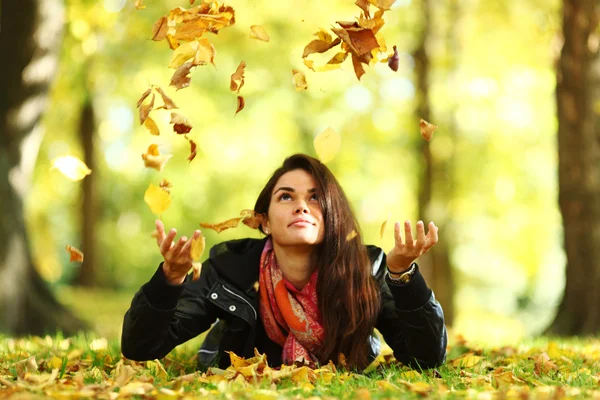 Mujer caída hojas en otoño parque —  Fotos de Stock