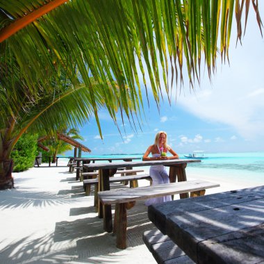 Woman in a tropical cafe clipart