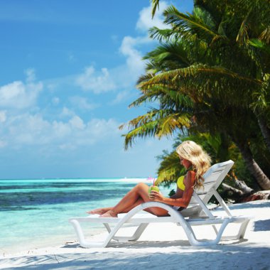 Tropical woman on lounge clipart