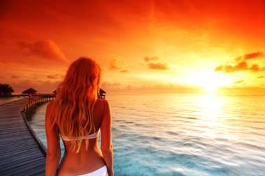 Woman in a dress on maldivian sunset clipart