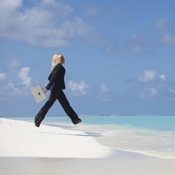 Business woman jump in ocean — Stock Photo, Image