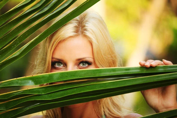 Frau hinter den Palmblättern — Stockfoto
