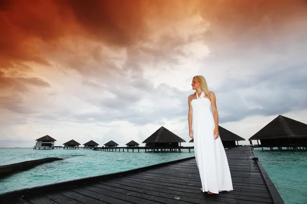 Mulher em um vestido no pôr do sol maldivo — Fotografia de Stock