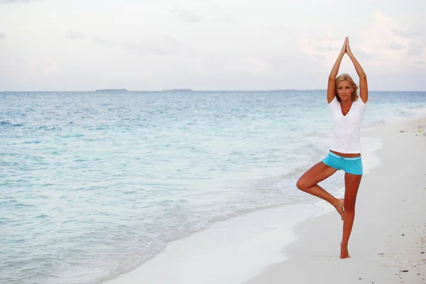 Kobieta jogi na wybrzeżu morza — Zdjęcie stockowe