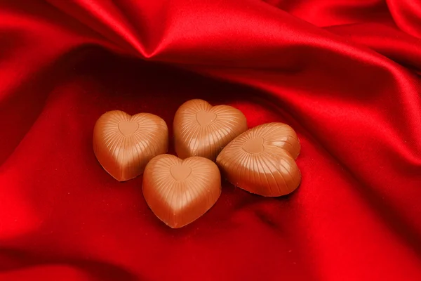 赤のサテンにハートのキャンディ — ストック写真