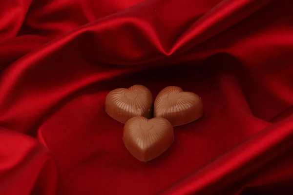 Candy srdce na červené saténové — Stock fotografie