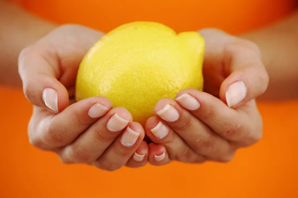 Лимон в женских руках — стоковое фото