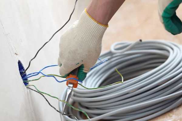 Trabajador pone los cables — Foto de Stock