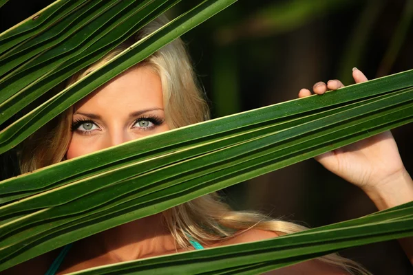 Mulher atrás das folhas da palma — Fotografia de Stock