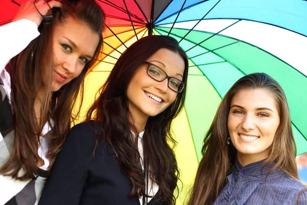 Lächelnde Freundinnen unter Regenschirm — Stockfoto