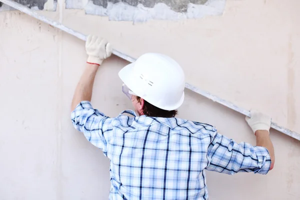 Worker aligns wall — Stock Photo, Image